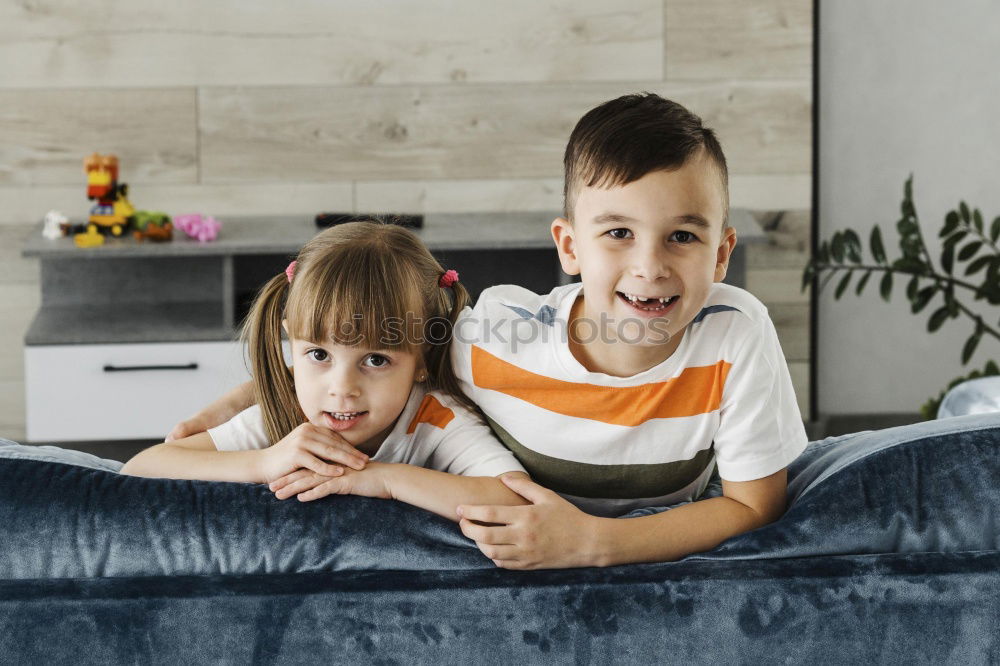 Image, Stock Photo Kids playing video game sitting on sofa at home