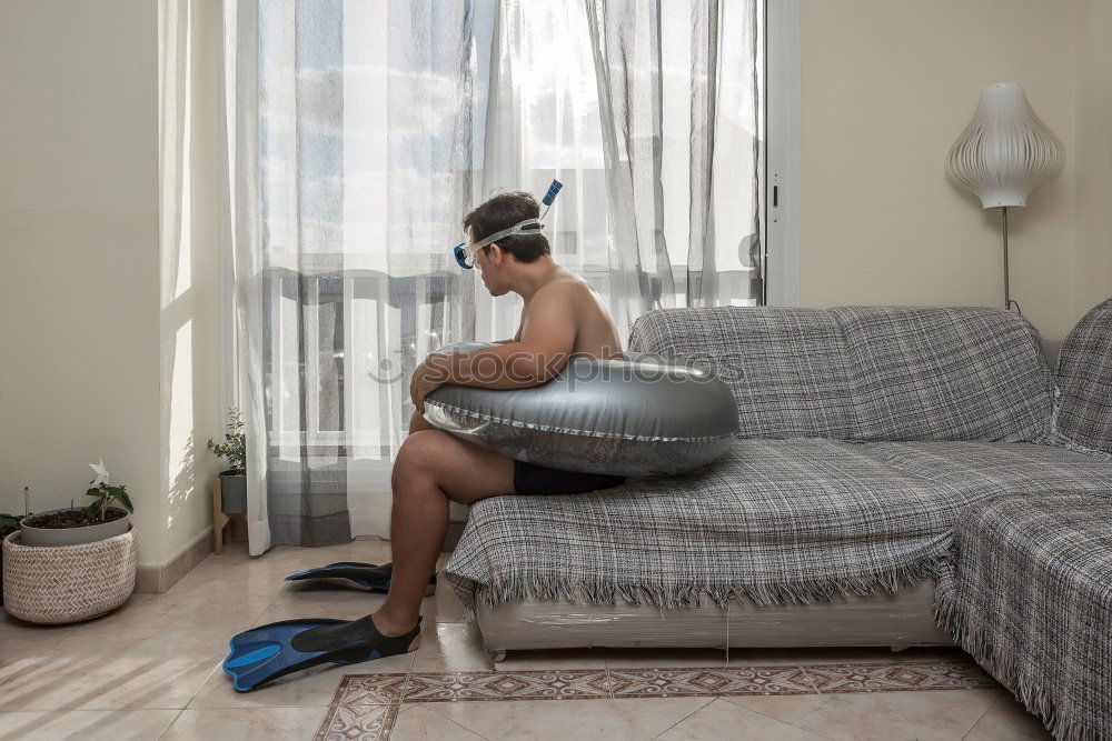 Similar – young, tall, long-legged woman stands barefoot with bare legs in front of a light sofa and looks into the camera