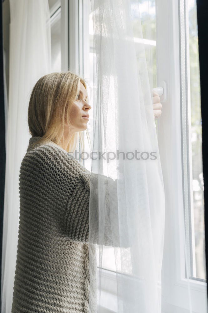 Similar – Dreaming girl looking away in window