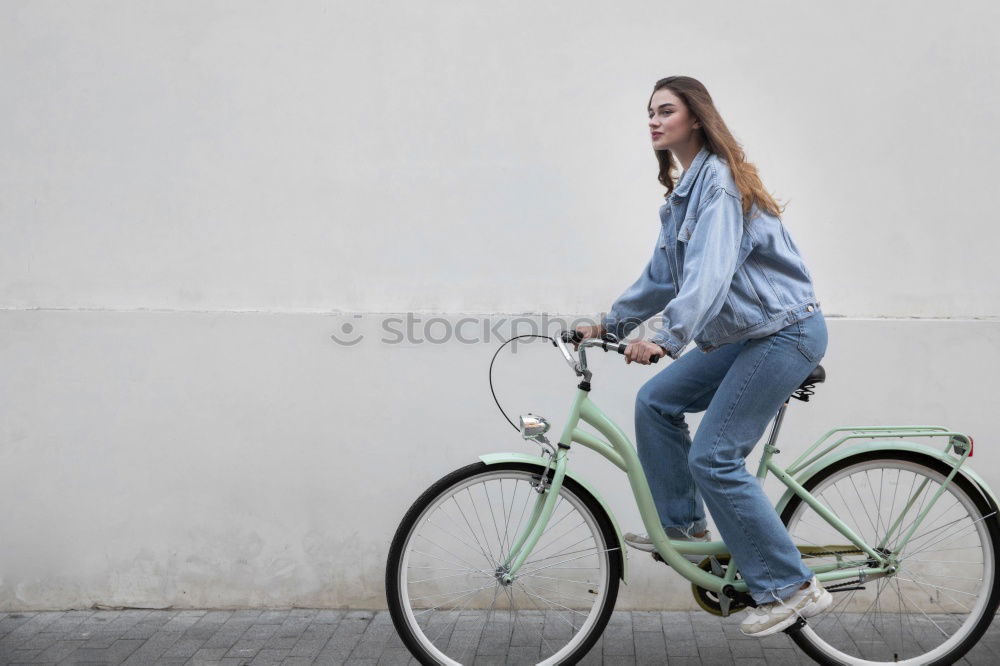 Similar – Young modern hipster riding bike trough urban city while sunset