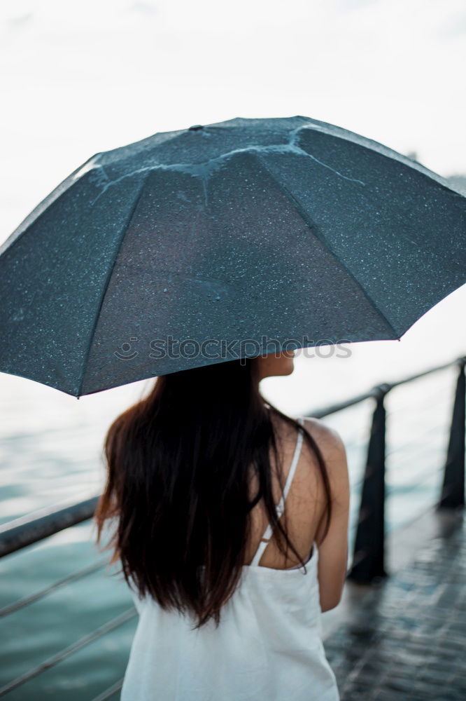 Similar – Image, Stock Photo Little girl holding big umbrella walking in a downtown on rainy gloomy autumn day