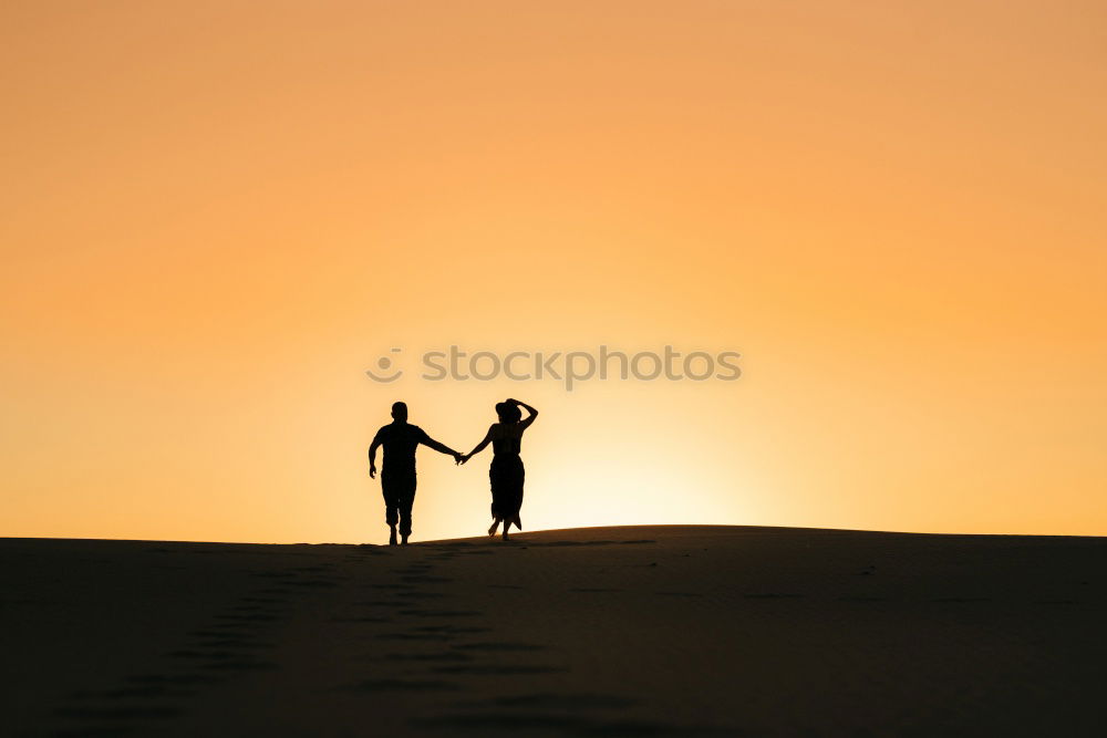 Similar – Mother and son holding hands on a beach at sunset