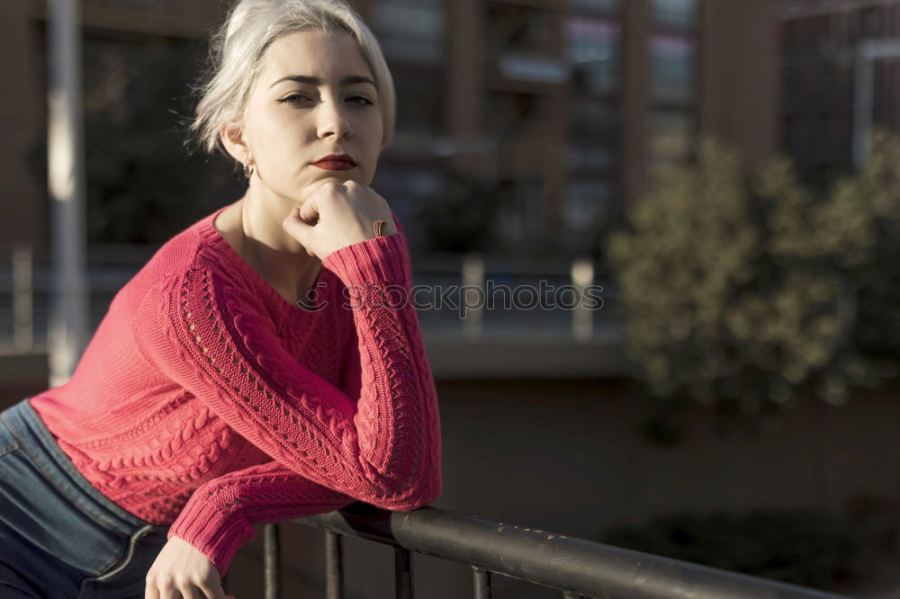 Similar – Portrait of a young blonde woman gesturing in the street wearing a red sweeter