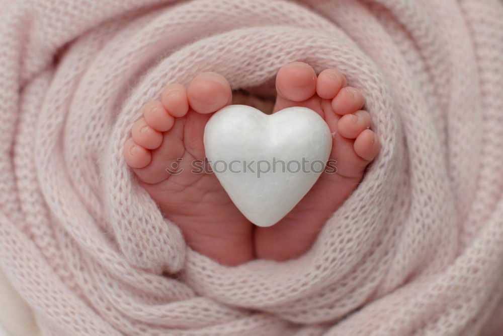 Similar – mother and father holding newborns feet in a heart shape