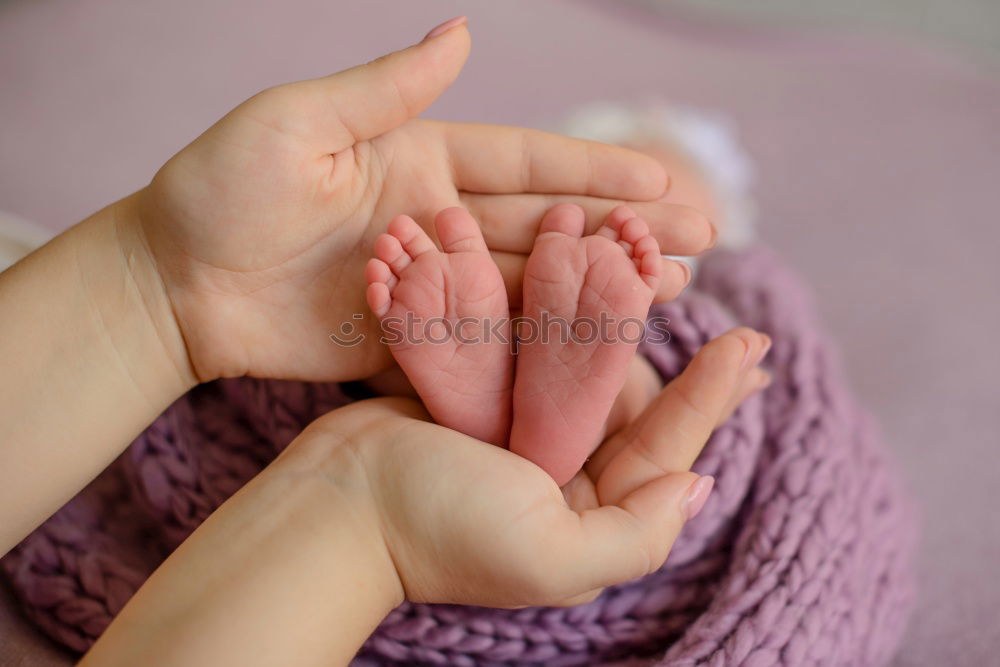 Similar – mother and father holding newborns feet in a heart shape