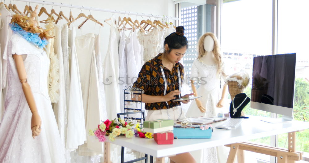 Young woman hanging clothes on coat hanger