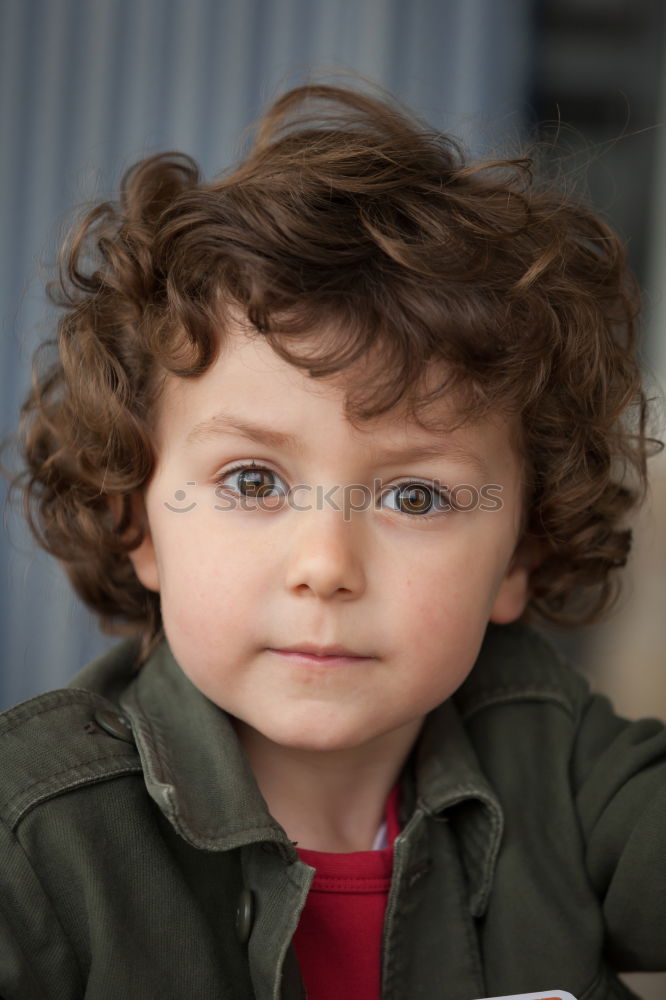 Small child with two years and curly hair looking at camera