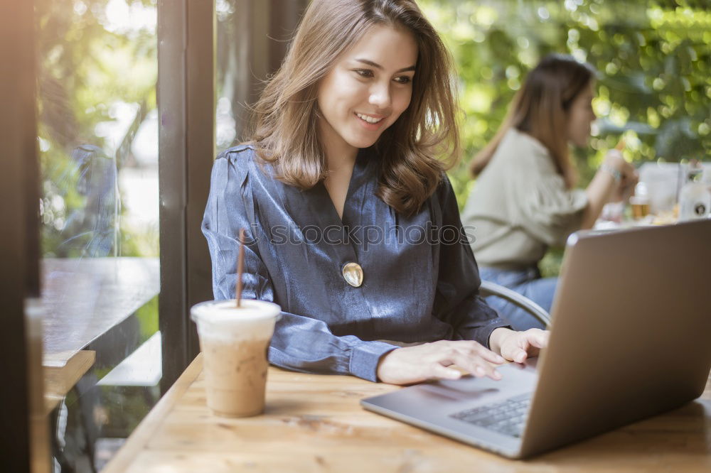 Similar – Young adult woman working on laptop in cafe