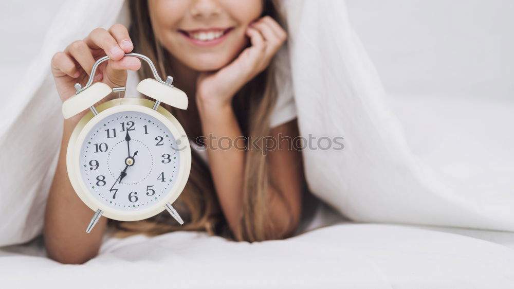 dog on bed with white sheets and alarm clock