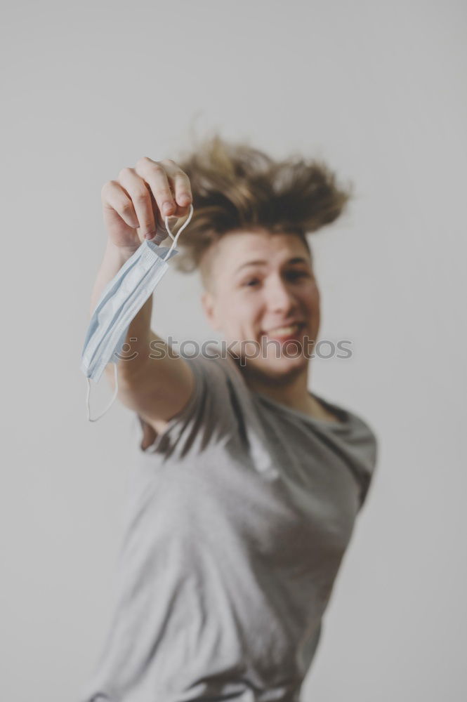 Portrait of young athletic slim woman in undershirt in front of green wall