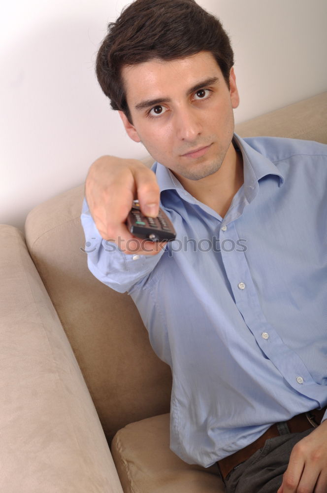 Relaxed boy holding smartphone sitting in chair at home