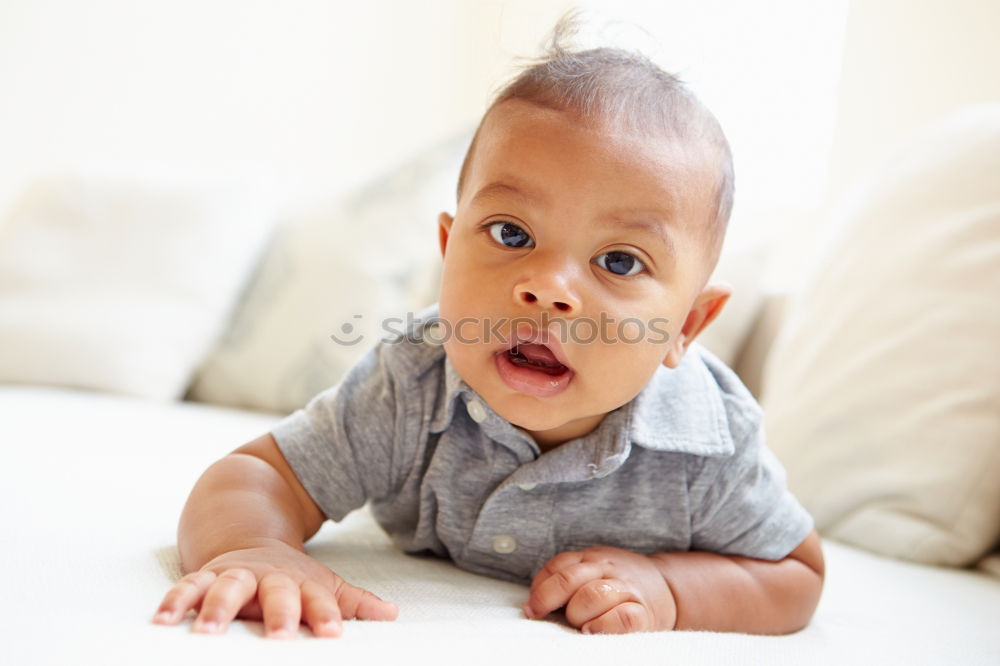 Similar – Cute male toddler laying on bed looking at camera