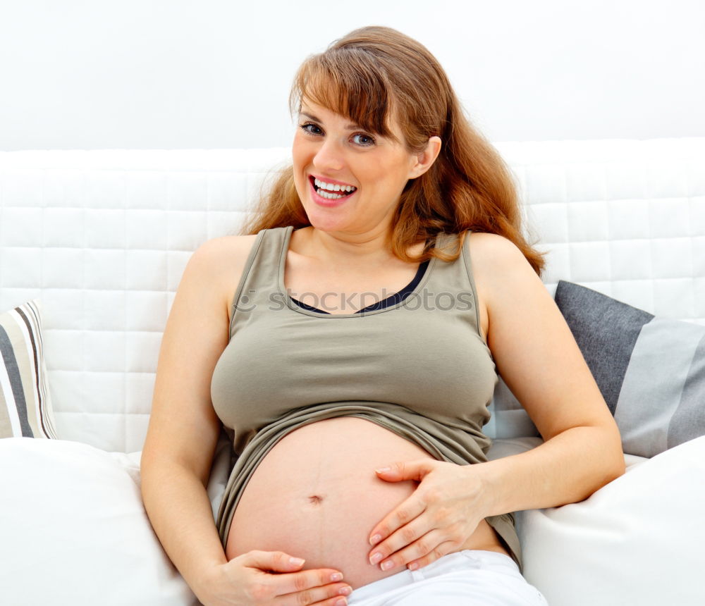 Similar – Happy pregnant woman sitting and touching her belly at home