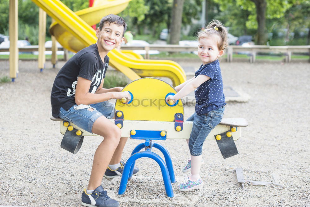 Similar – Cute caucasian siblings sitting on slide on playground