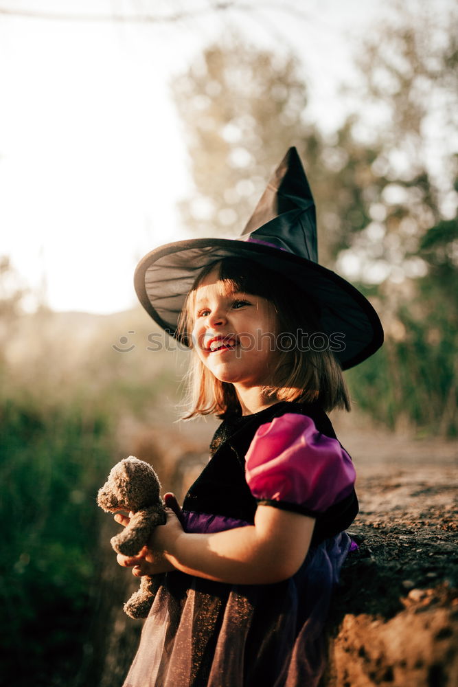 Similar – Cheerful kid in costume posing on tree