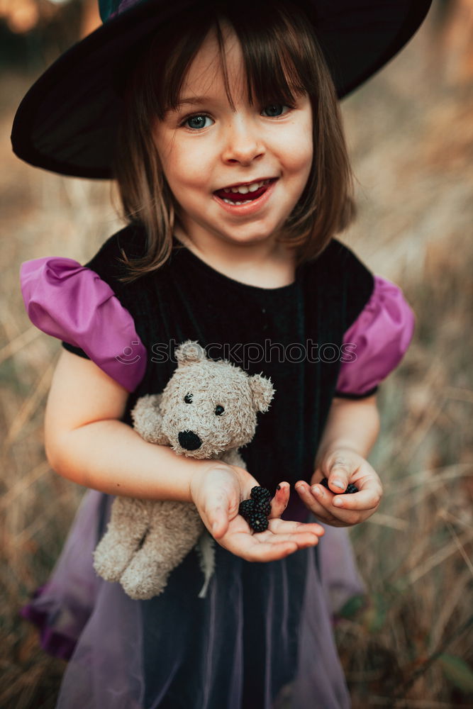 Similar – Cheerful kid in costume posing on tree