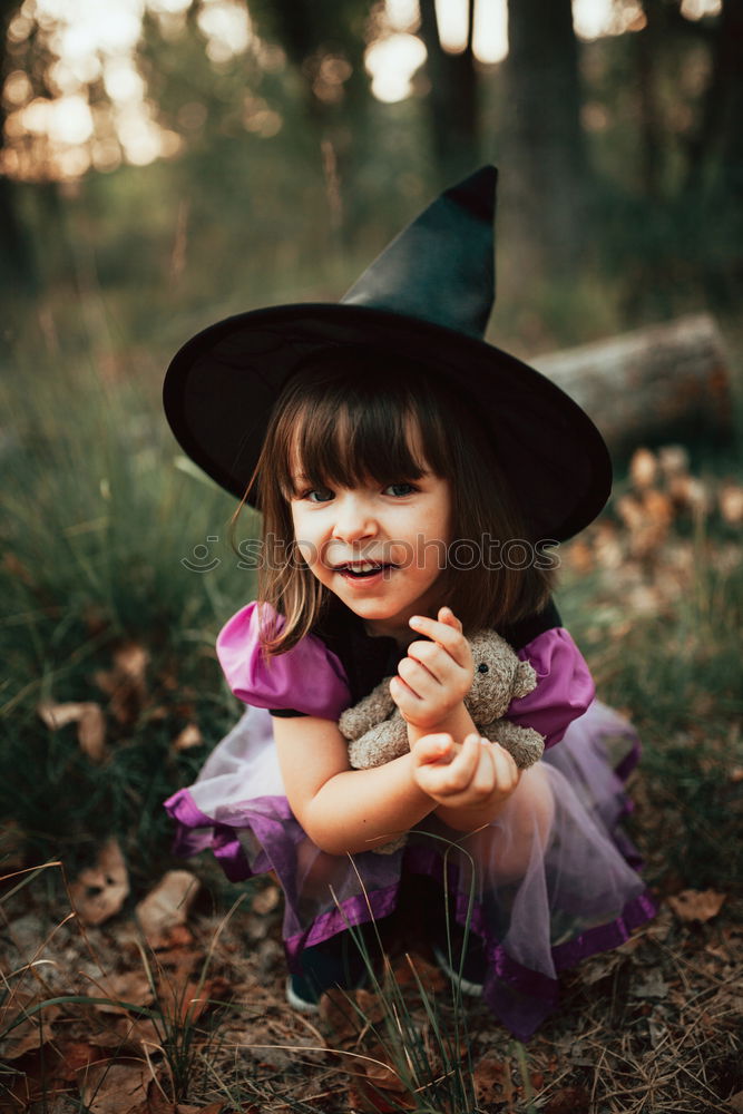 Similar – Cheerful kid in costume posing on tree