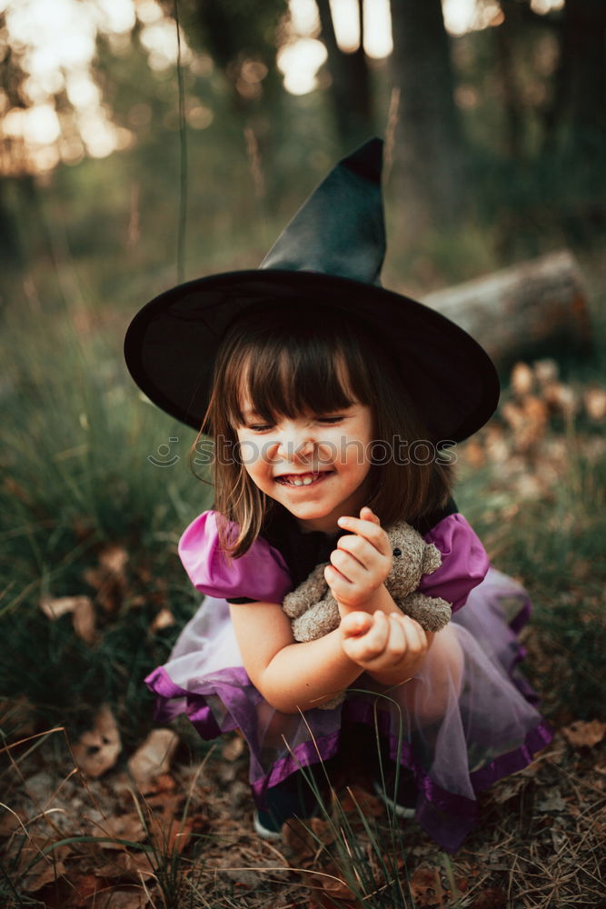 Similar – Cheerful kid in costume posing on tree