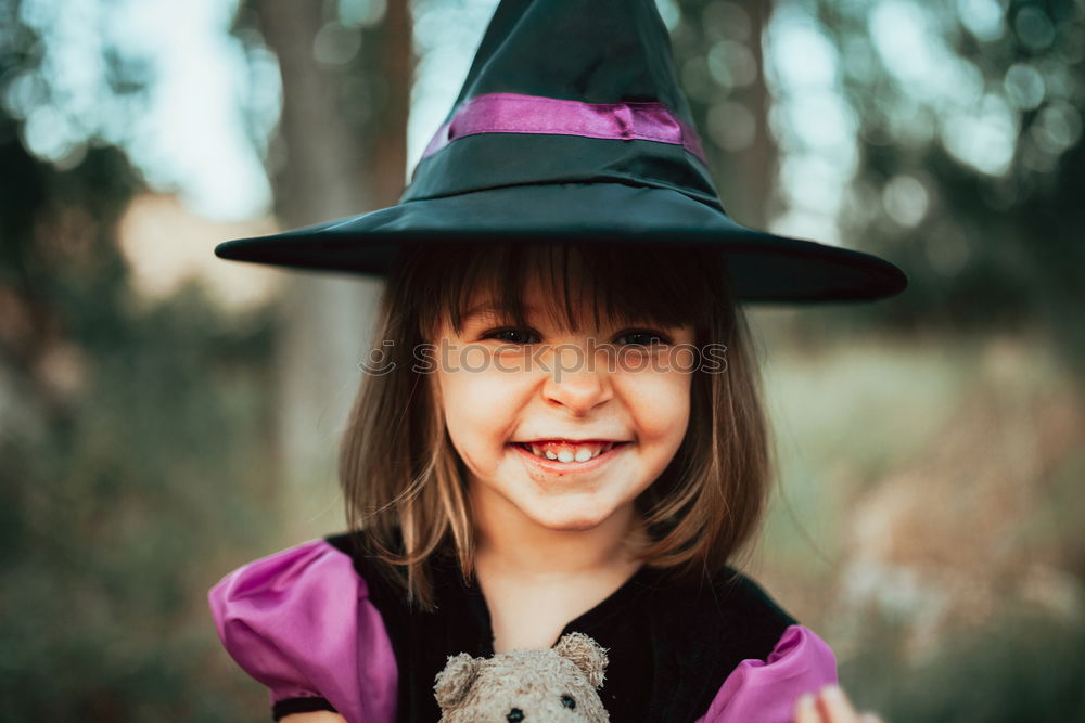 Similar – Cheerful kid in costume posing on tree