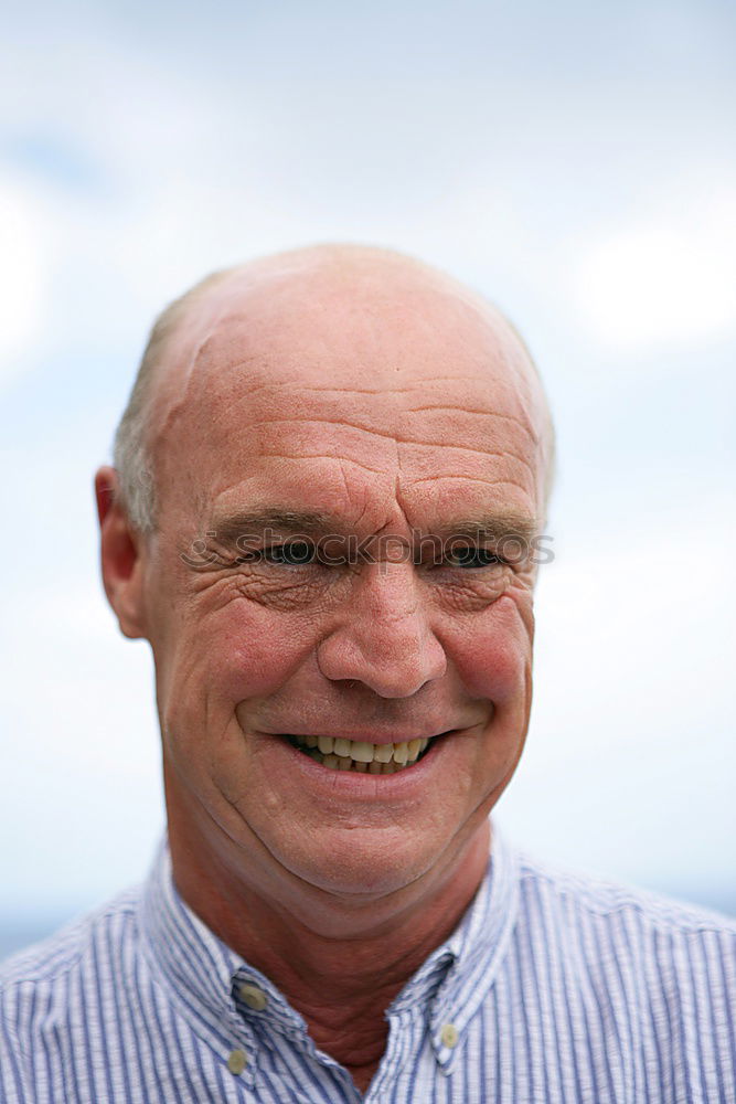 Similar – Portrait of a senior citizen with short grey hair and three-day beard in front of a blue-grey sky