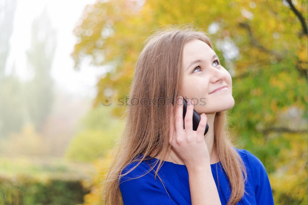 Similar – Image, Stock Photo Smiling young woman chatting on a mobile in autumn