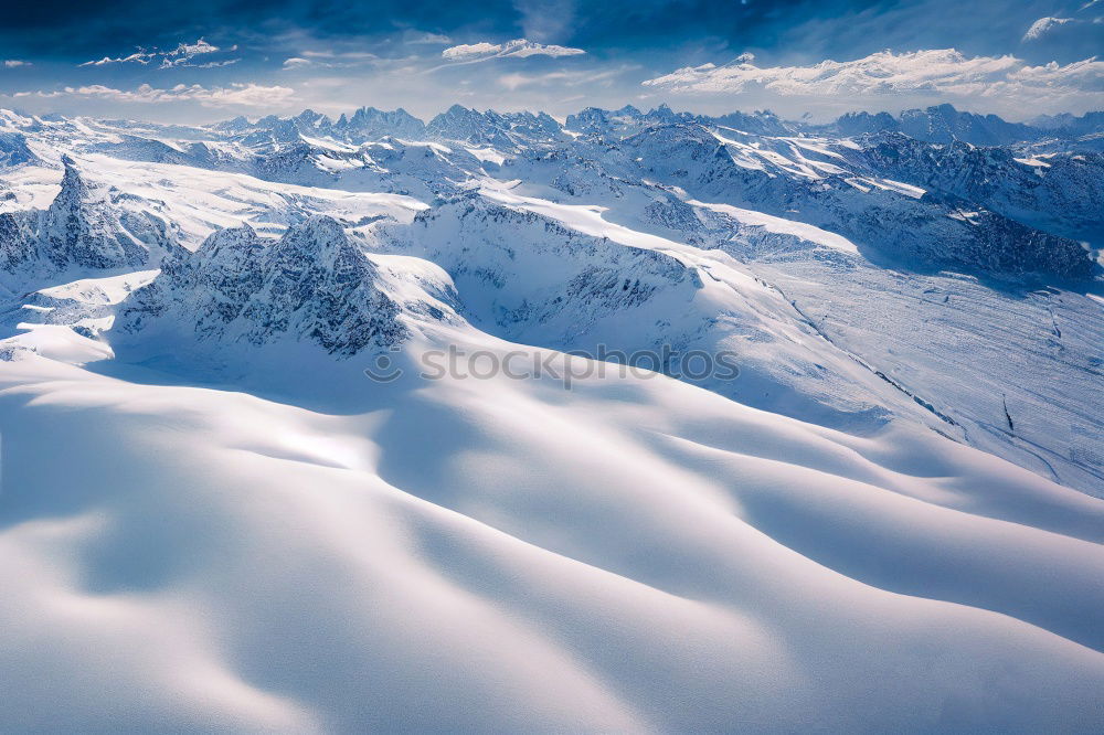 Similar – Snowy blue mountains in clouds at sunset