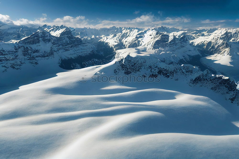 Snowy blue mountains in clouds at sunset