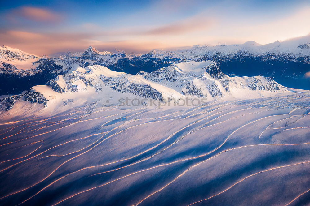 Similar – Snowy blue mountains in clouds at sunset