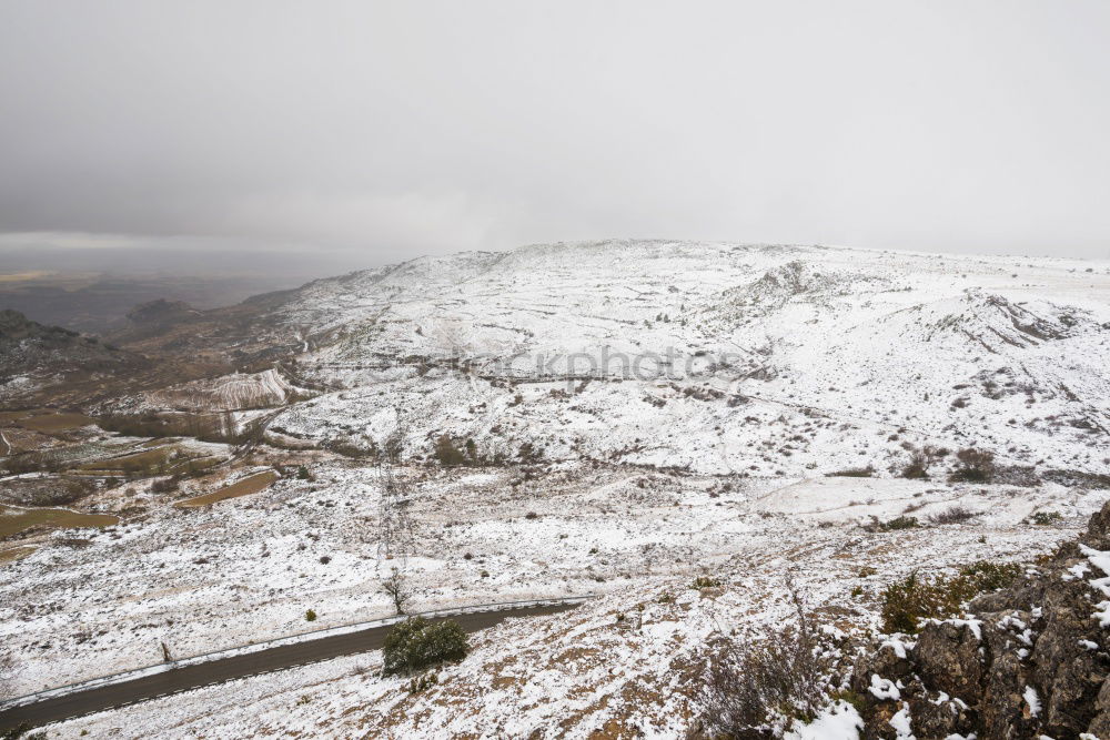 Similar – Image, Stock Photo Cyclist goes downhill along a mountain road in a snowy landscape