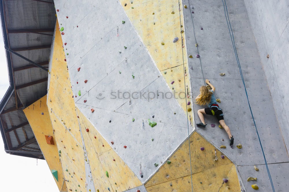 Similar – Man practicing rock climbing on artificial wall indoors.