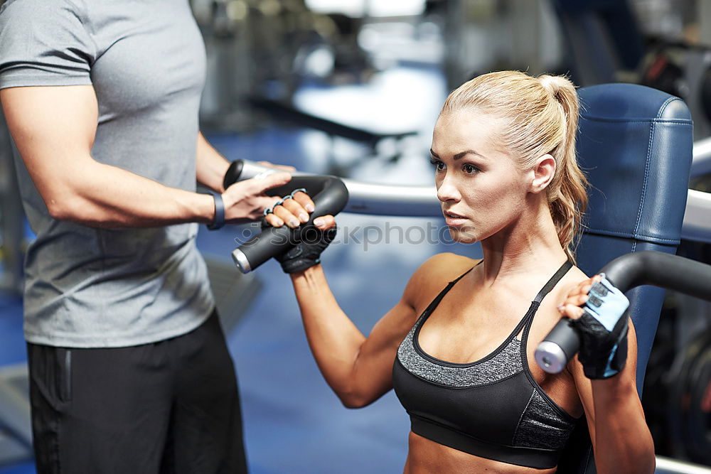 Similar – Personal trainer helping young woman lift weights