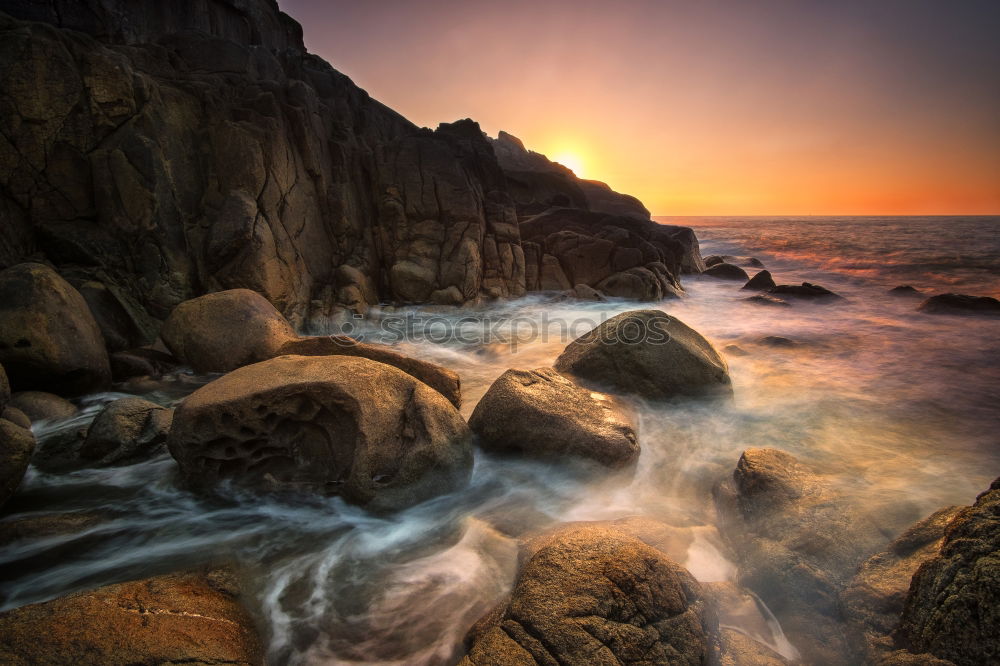 Similar – Sea crashes light waves into rocky bay, long exposure