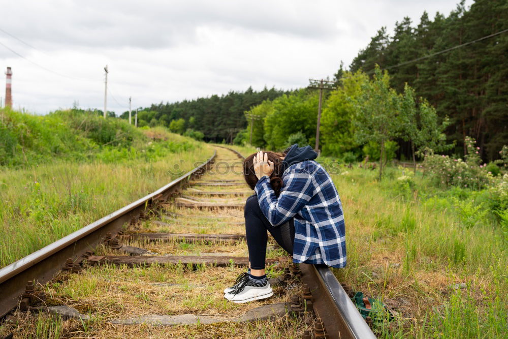 Similar – Sad girl teenager sitting on rusty rail track outside the town. Escape to be alone