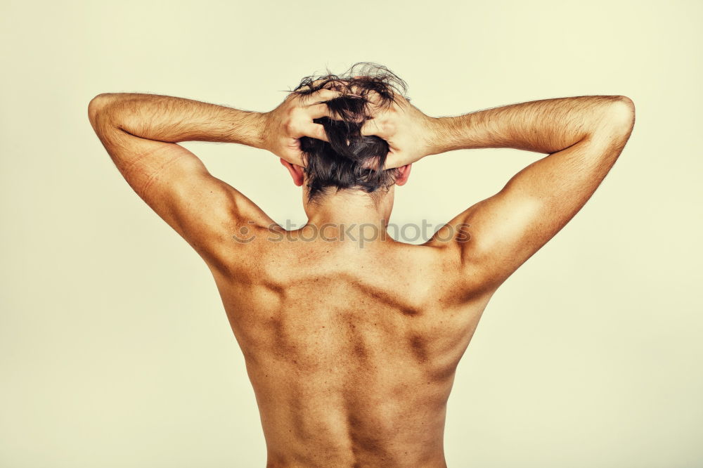 Similar – young woman with very short hair stands naked in front of light turquoise wall in pose with half raised arms