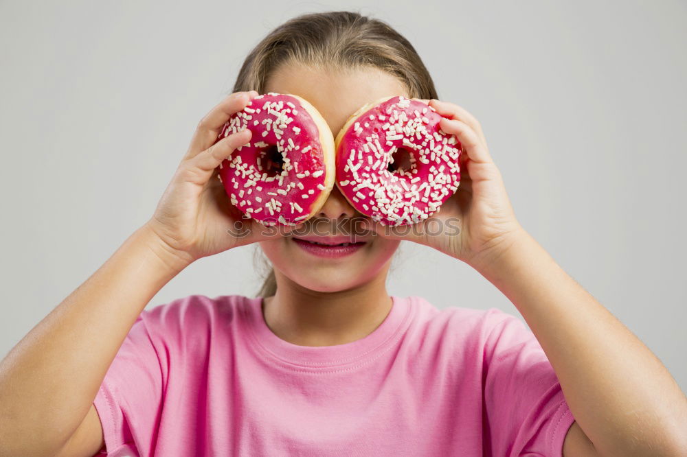 Similar – Young woman pulling funny face holding donuts in hands