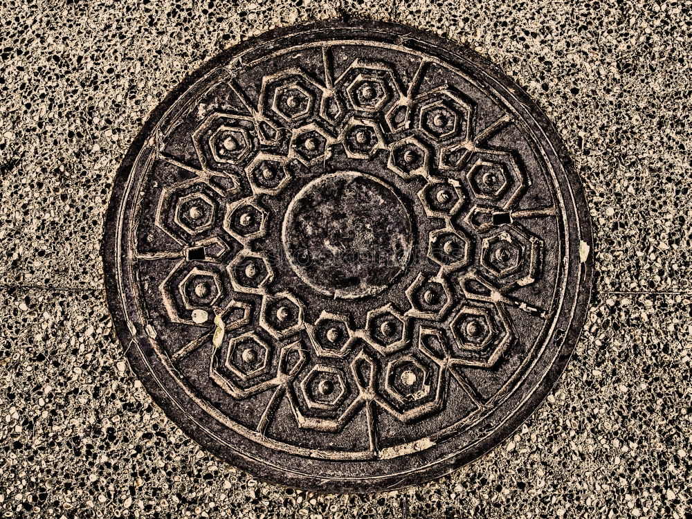 Similar – Gully cover with embedded cobblestones with grey paving stones arranged in a circle in pouring rain