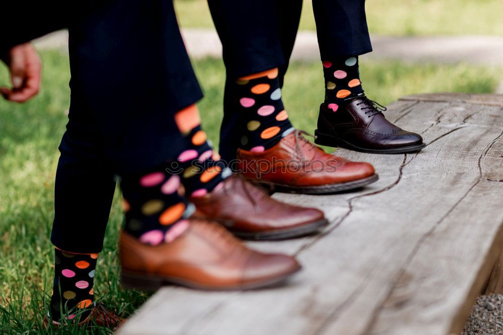 stylish men’s socks. Stylish suitcase, men’s legs, multicolored socks and new shoes. Concept of style, fashion, beauty and vacation