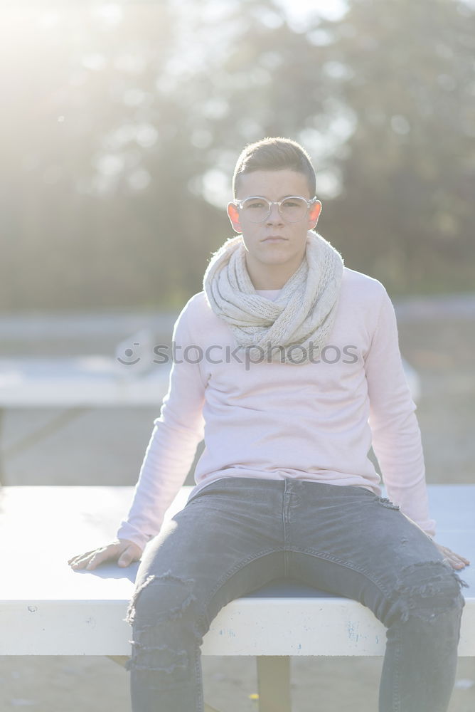 Similar – Stylish smiling teenager sitting on the ground in a city park