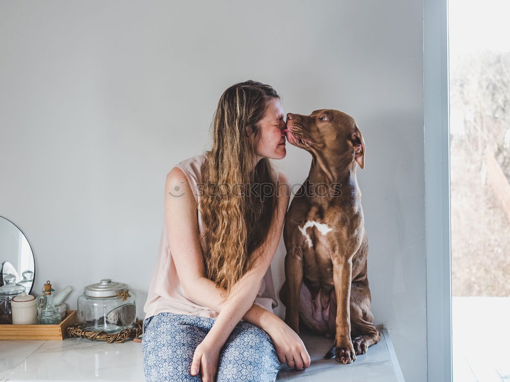 A pretty girl hugs her pet while kissing her