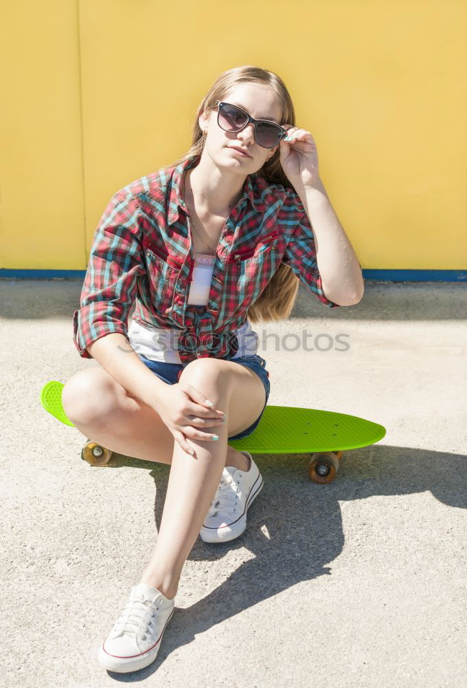 Similar – boy sitting on ground leaning on a wall, taking a selfie