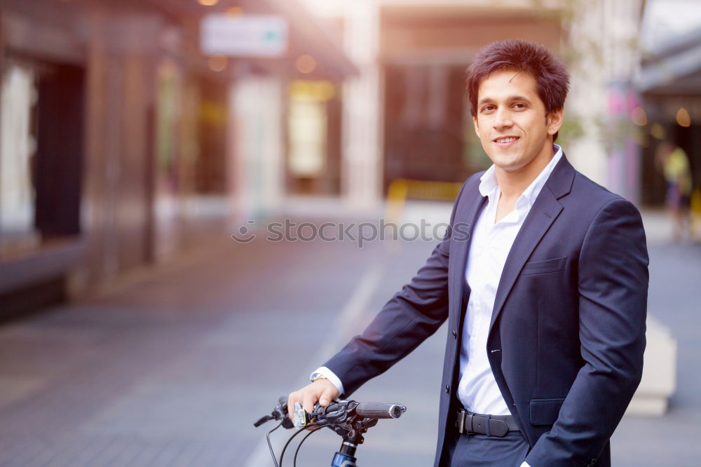 Man in the street wearing suit near a vintage bicycle.