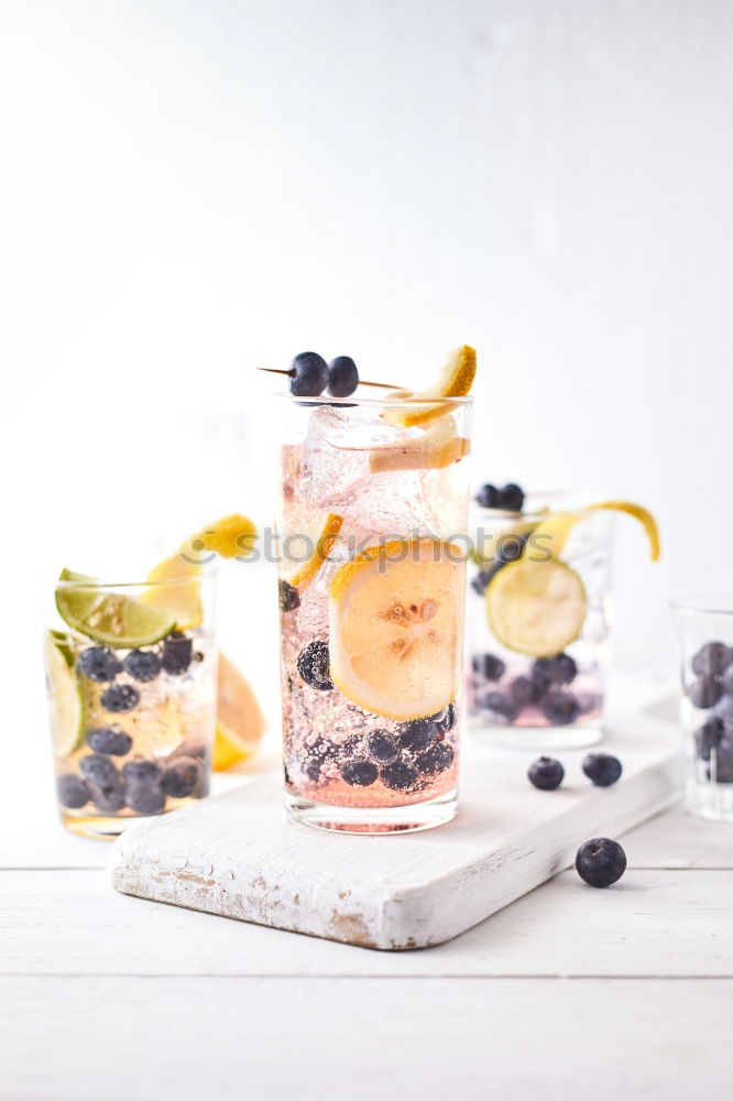 Similar – Berry-fruity water, iced with raspberries, blueberries, ice cubes and drinking straw on white background