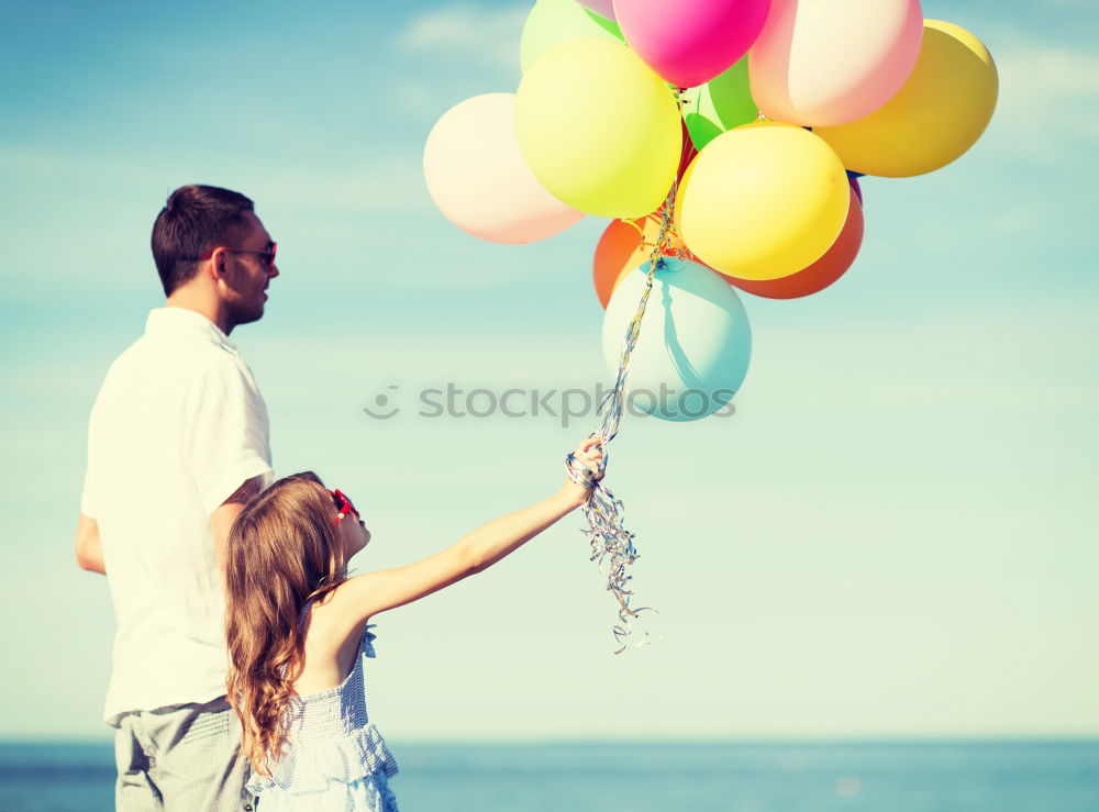 Similar – Father and daughter with balloons playing on the beach at the day time. Concept of friendly family.