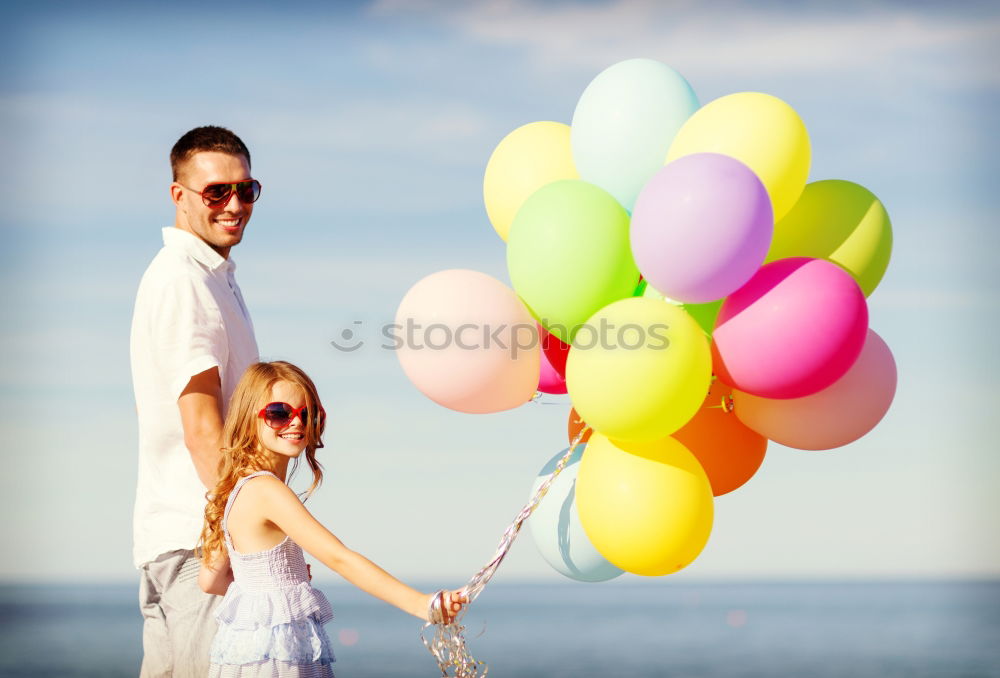 Similar – Father and daughter with balloons playing on the beach at the day time. Concept of friendly family.