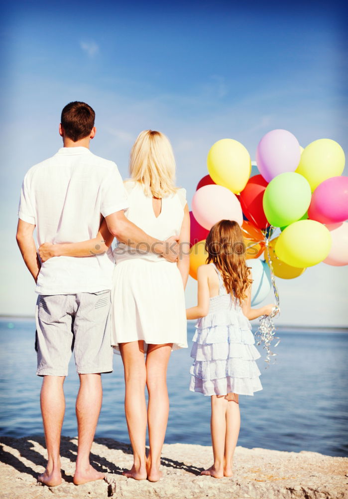 Similar – Father and daughter with balloons playing on the beach