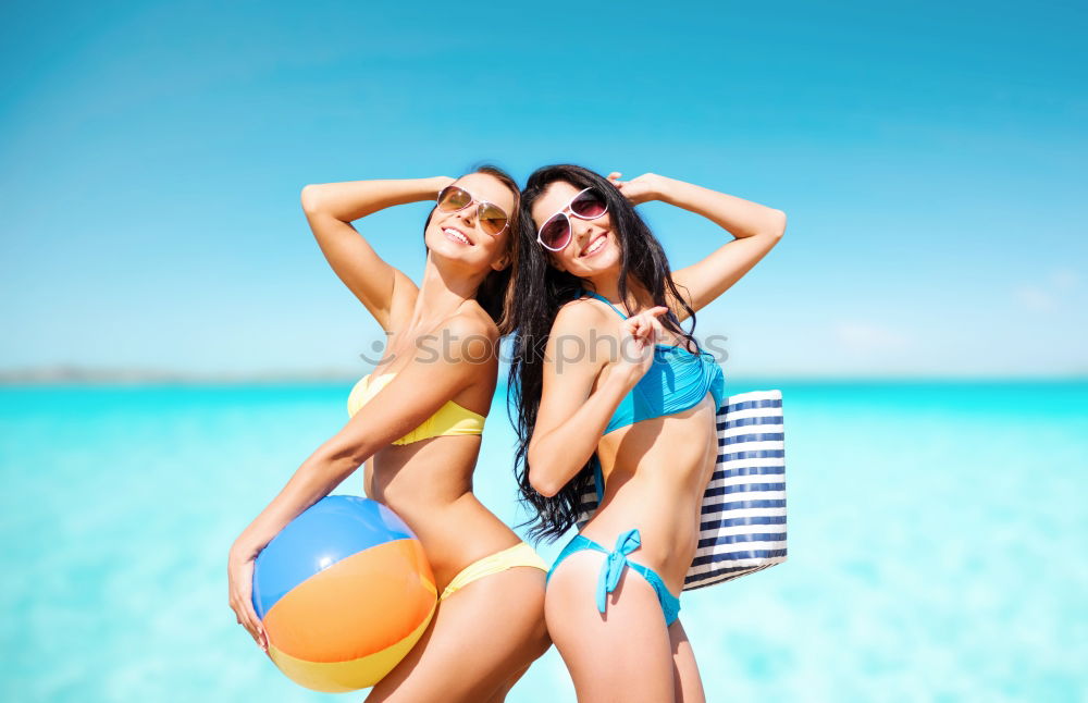 Similar – Zwei Frauen im Bikini, die auf einem tropischen Strandsand sitzen.