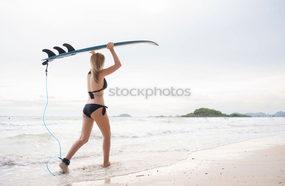 Similar – A young woman sitting under a surfboard