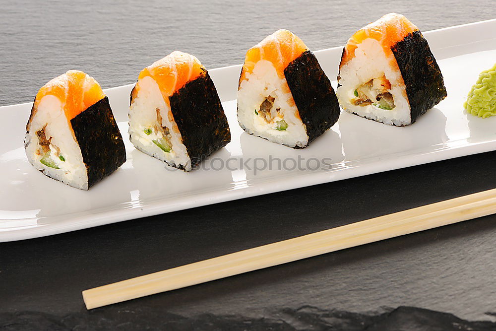 sushi assortment in white plate on black background