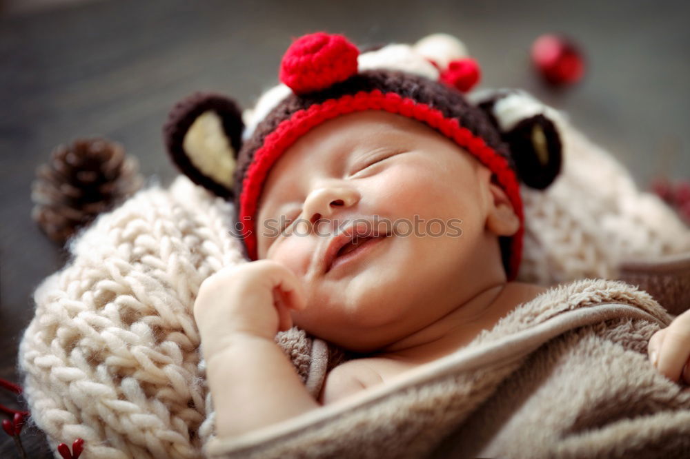 Adorable baby sleeping wrapped in a red blanket