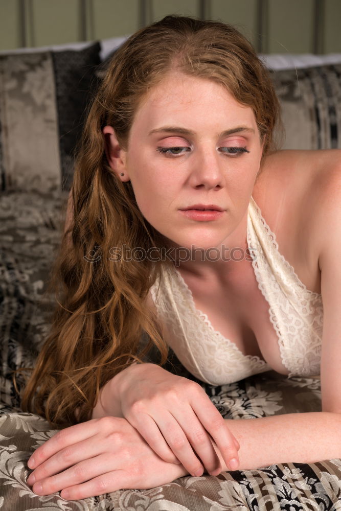 Similar – Young woman sits barefoot in undershirt on a flowered couch and looks sideways into the camera